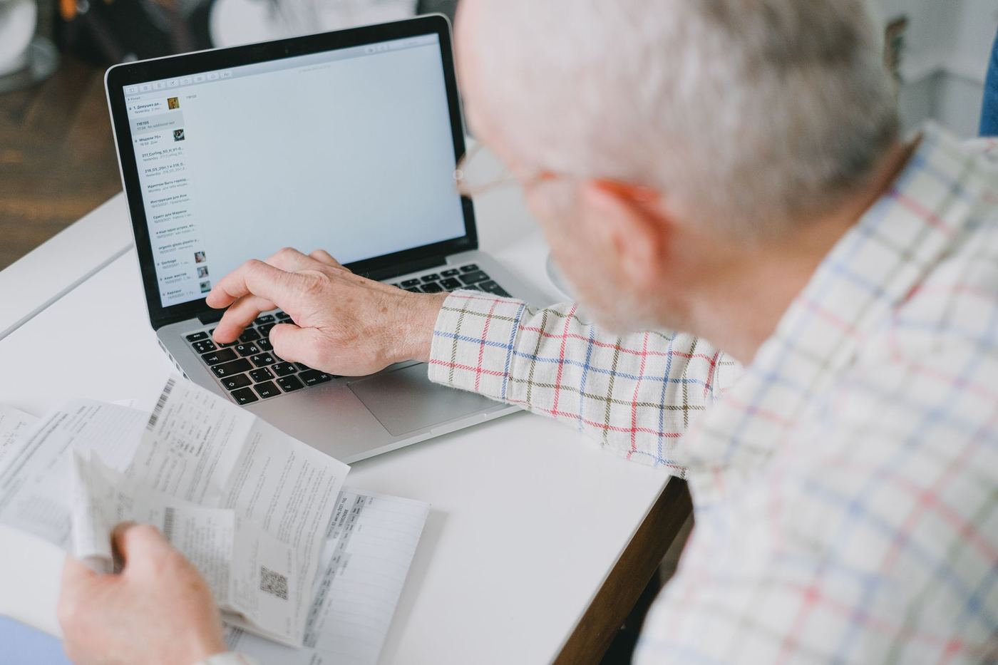 Shop owner working through invoices and paperwork at a laptop after hours